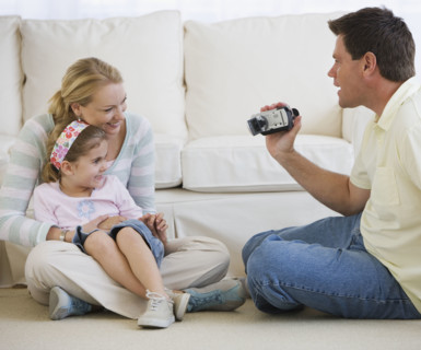 Father video recording mother and daughter.