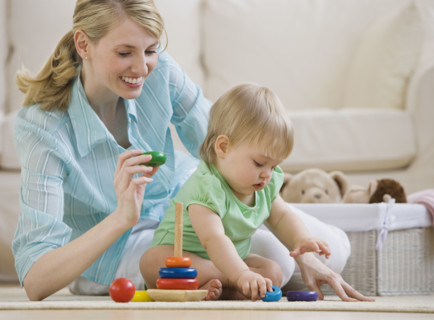 Mother and baby playing on floor.