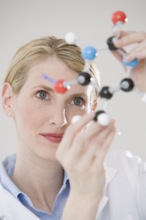 Female scientist looking at molecule model.