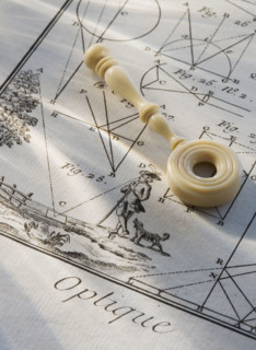 Old fashioned magnifying glass on diagram.