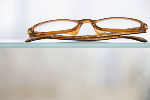 Close up of eye glasses on shelf.