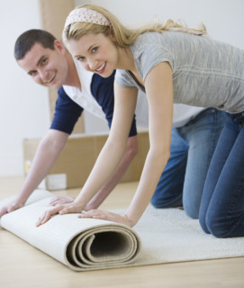 Couple unrolling rug.