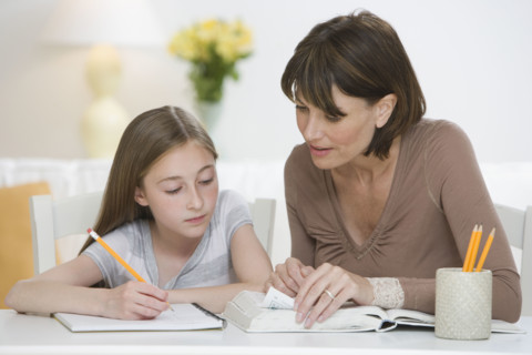 Mother helping daughter with homework.