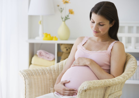 Pregnant woman with hands on belly.