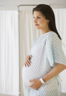 Pregnant woman in hospital gown.
