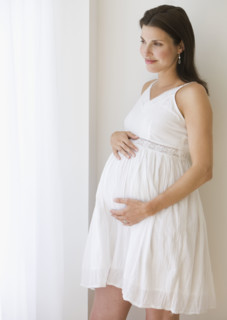 Pregnant woman with hands on belly.