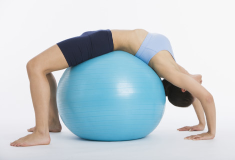 Woman stretching on exercise ball.
