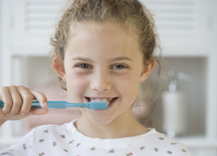 Girl brushing teeth.