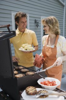 Couple barbequing on deck.