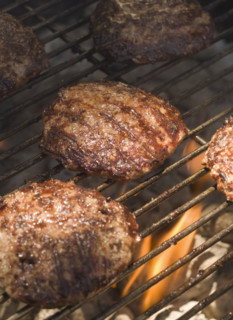 Hamburgers cooking on grill.