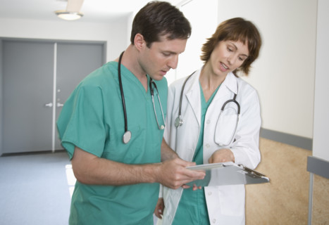 Female and male doctors discussing chart.