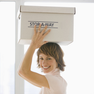 Businesswoman carrying storage box on head.