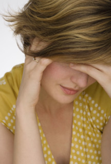 Close up of woman with head in hand.