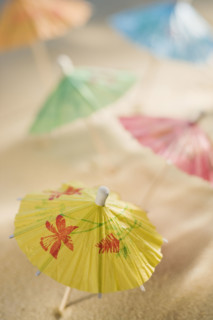 Cocktail umbrellas in sand.