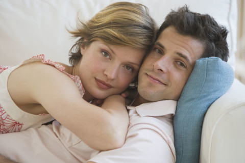 Couple hugging on sofa.