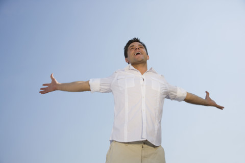Low angle view of man with arms outstretched.