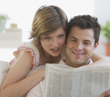 Couple reading newspaper.