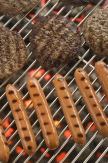 Hamburgers and hot dogs cooking on grill.