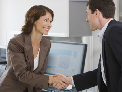 Businesswoman and businessman shaking hands.