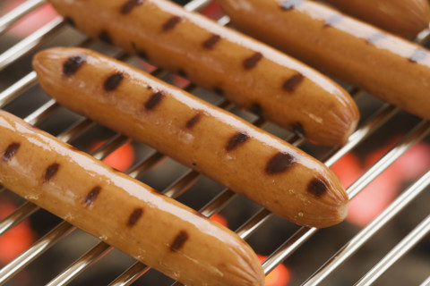 Hot dogs cooking on grill.