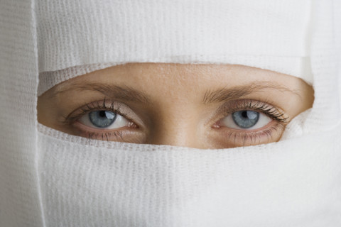 Woman’s face wrapped in bandages.