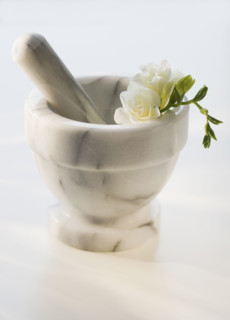 Mortar and pestle with flower.