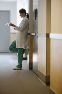 Female doctor reading chart.