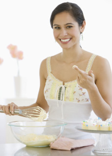 Woman stirring batter in kitchen.