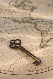 Old fashioned key on globe map.