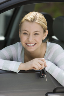 Woman holding car keys in car.