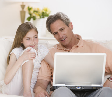 Father and daughter looking at laptop.