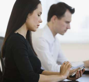 Businesswoman using electronic organizer.
