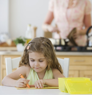 Girl coloring at kitchen table.