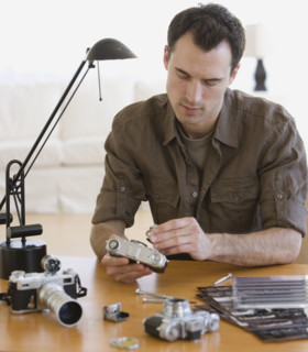 Man assembling camera at table.
