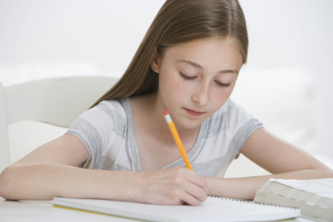 Girl doing homework at table.