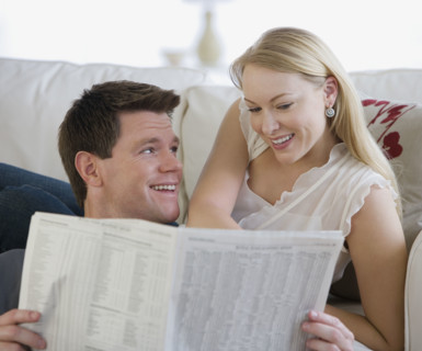 Couple reading newspaper.
