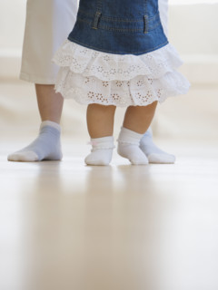 Mother helping baby walk.