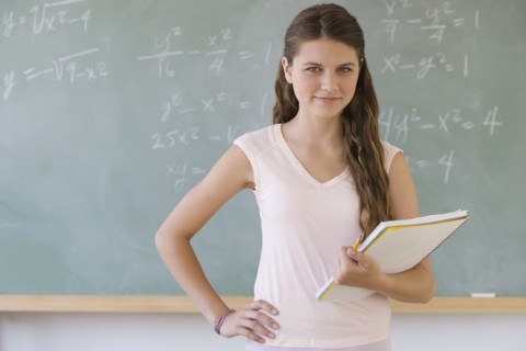 Girl standing in front of blackboard.