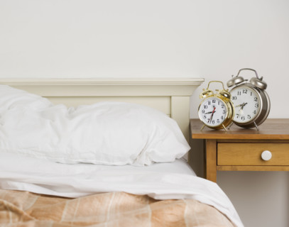 Unmade bed with alarm clocks. Date : 2006