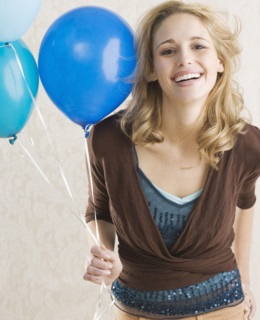 Woman holding balloons and smiling. Date : 2006
