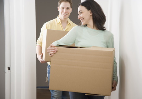 Couple carrying boxes in new house. Date : 2006