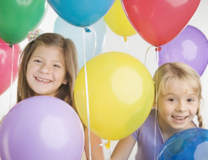 Young sisters smiling with balloons. Date : 2006