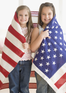 Portrait of sisters wrapped in American flag. Date : 2006