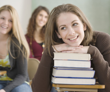 Female student leaning on stack of books. Date : 2007