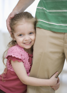 Girl hugging father’s leg. Date : 2007