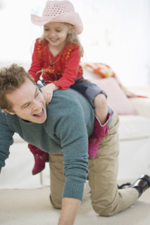 Father and daughter playing in livingroom. Date : 2007