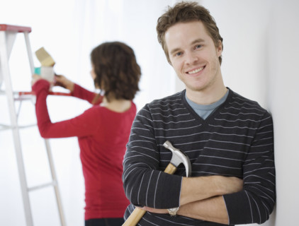 Man leaning on wall holding hammer. Date : 2007