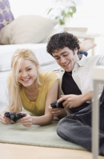 Couple playing video games on floor. Date : 2007