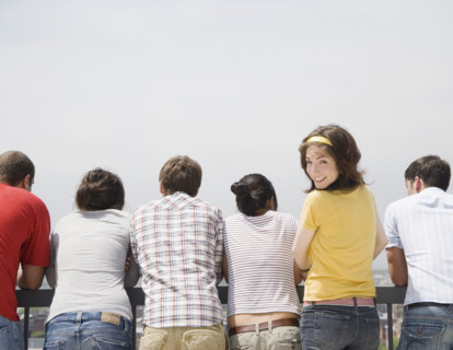 Rear view of friends with woman looking over shoulder. Date : 2007