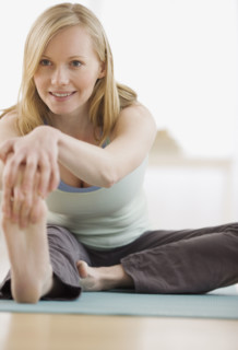 Woman stretching on yoga mat. Date : 2007